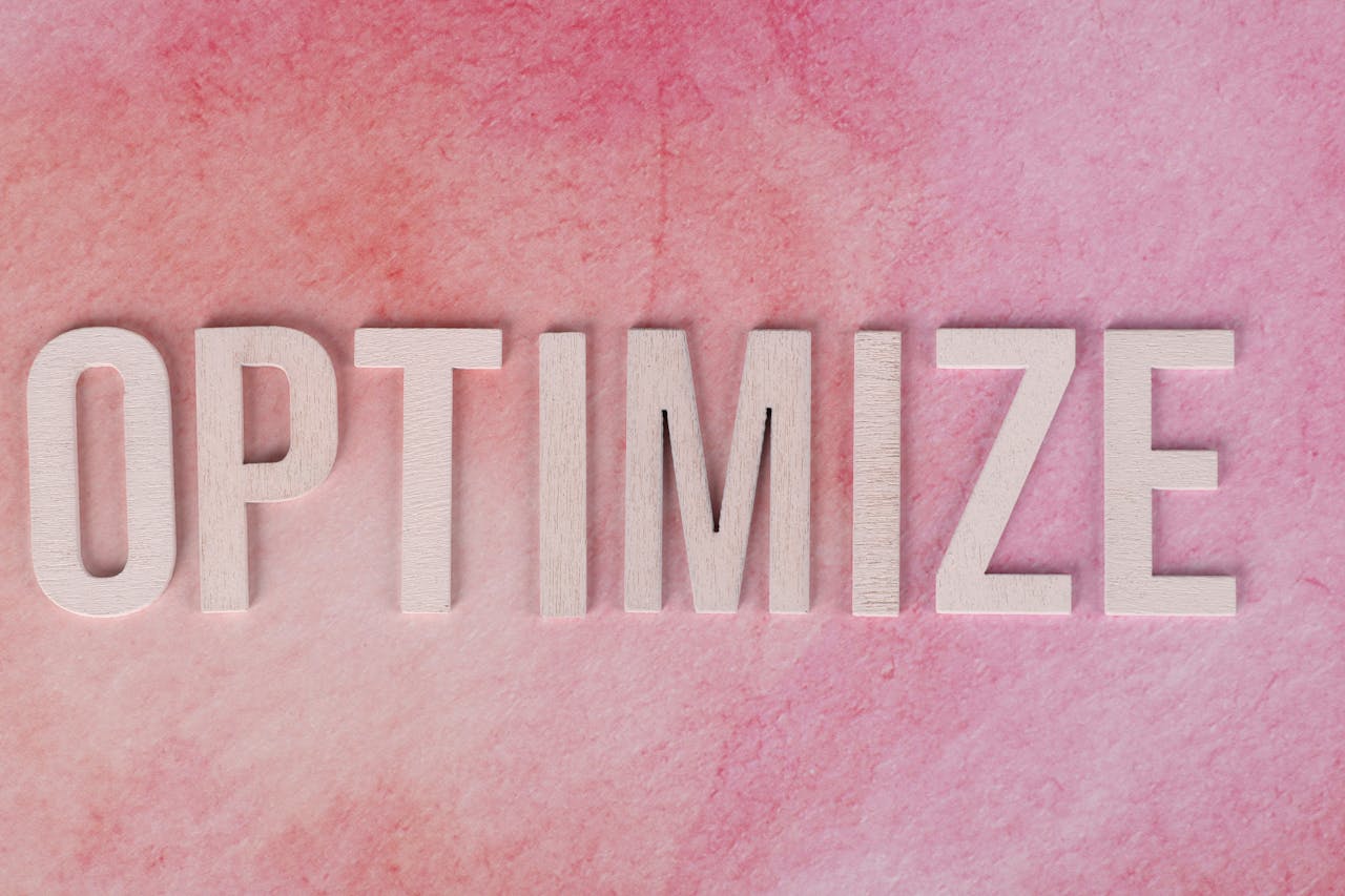 services-02 Creative display of the word OPTIMIZE on a pink textured surface.